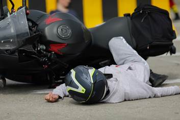 A child lying on the ground next to a motorcycle

AI-generated content may be incorrect.